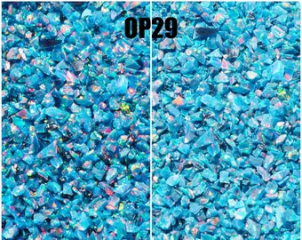May include: Close-up of crushed, iridescent blue opal chips, with the text "OP29" at the top. The left side is labeled "Wet" and the right side is labeled "Dry", showing the color difference. The image is from OpalandFindings.com.
