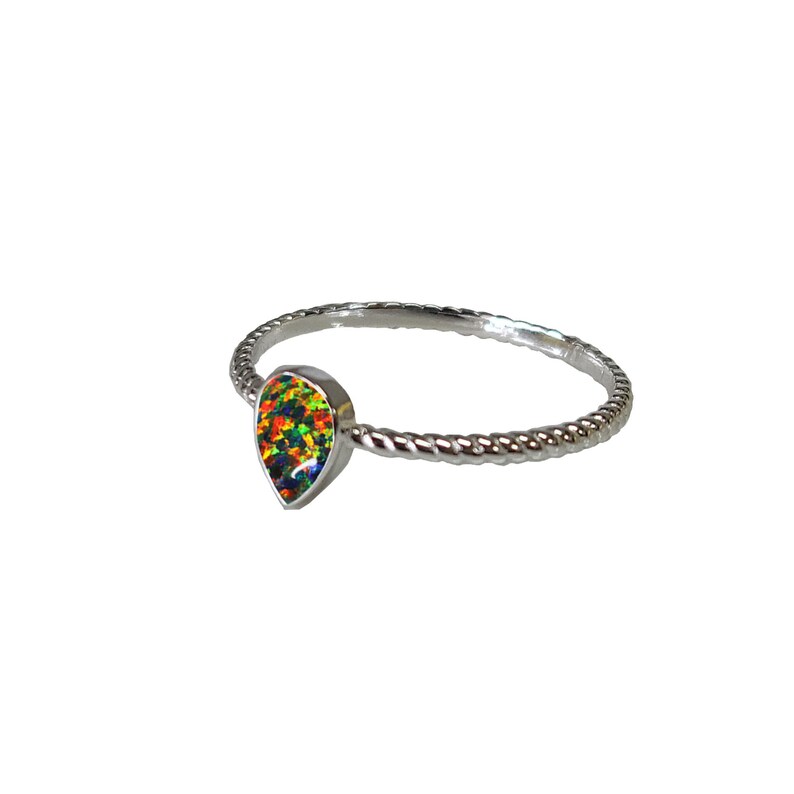 May include: A silver ring with a teardrop-shaped opal gemstone. The opal is a vibrant mix of green, orange, red, and blue.