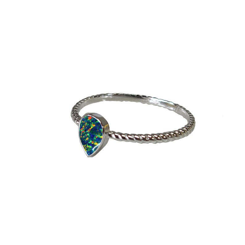 May include: A silver ring with a teardrop-shaped opal gemstone. The opal is a vibrant blue-green with flashes of red and orange.