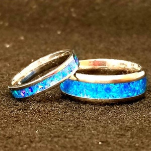 Cremation Creations Ring Set, of 2 Titanium Rings inlaid with ashes and opal.