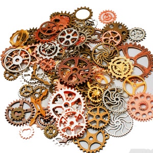 May include: A collection of assorted metal gears in various sizes and colors, including gold, silver, copper, and bronze. The gears are arranged in a random pattern on a white background.