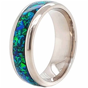 May include: A silver band ring with a blue and green opal inlay.