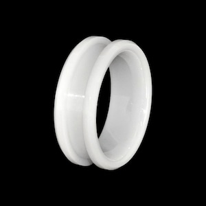 May include: White plastic ear gauge with a smooth, rounded surface. The gauge is designed to stretch the earlobe.