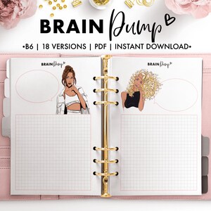 May include: A pink binder with gold rings and two pages open. The pages are lined with a grid pattern and feature illustrations of women with thought bubbles. The text "BRAIN Dump" is printed on the top of the pages.