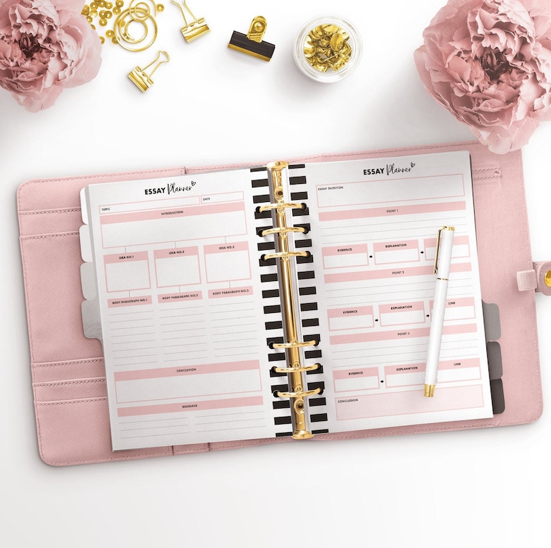 May include: A pink and black planner with gold rings, labeled "Essay Planner". The planner has sections for essay planning, including topic, introduction, ideas, body paragraphs, conclusion, and references.