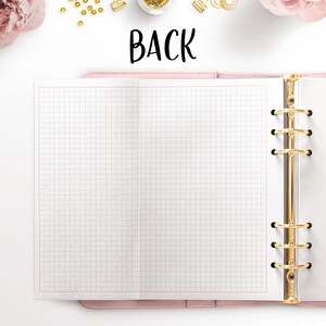 May include: A pink leather bound notebook with a gold ring binder and a blank gridded page open. The notebook is on a white surface with the word "BACK" written in black above it.