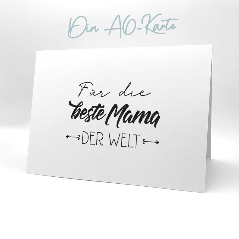 May include: A white card with black text that reads "F&uuml;r die beste Mama der Welt" which translates to "For the best Mom in the world".