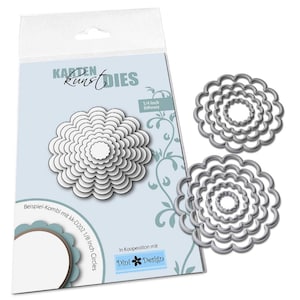 Könnte beinhalten: Ein Paket mit blütenförmigen Stanzformen mit dem Text "Karten Kunst Dies". Das Paket zeigt ein mehrschichtiges Blumendesign. Drei Metallstanzformen in Form von geschichteten Blüten werden ebenfalls angezeigt. Der Text "1/4 Inch Differenz" ist sichtbar.