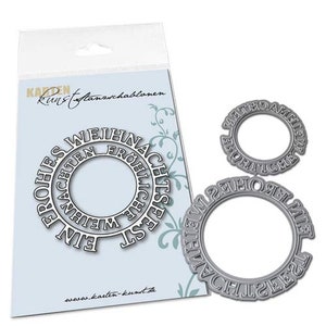 May include: Two silver metal die-cut stencils for crafting. The larger stencil is a circle with the words "Frohe Weihnachten" and "Ein Frohes Weihnachtsfest" in a circular pattern. The smaller stencil is a circle with the words "Frohe Weihnachten" in a circular pattern.