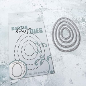 May include: A set of four oval-shaped metal dies with a beaded edge. The dies are nested inside each other and are packaged in a clear plastic bag with a white card that says "Karten Kunst Dies" and "Kombinierbar mit D085 Easter Eggs".