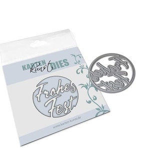 May include: A silver metal die cut with the words "Frohes Fest" in a circle. The die cut is on a white background with a floral design and the text "Karten Kunst Dies" in the top left corner.