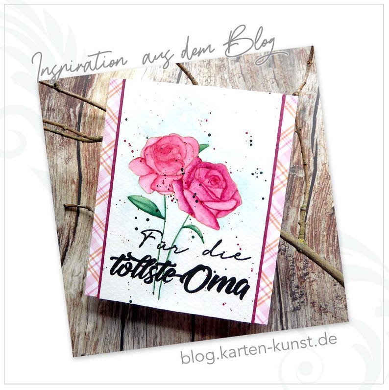 May include: A white card with two pink watercolor roses and the text "F&uuml;r die tollste Oma" on a wooden background.