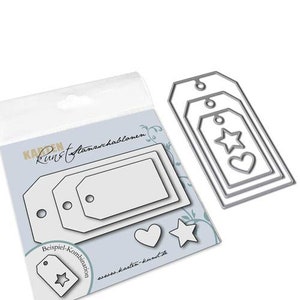 Könnte beinhalten: Ein Satz mit drei Metall-Stanzschablonen zum Basteln. Die Schablonen sind in Form von Geschenkanhängern mit einem Stern, einem Herzen und einem kleineren Anhänger im Inneren. Die Schablonen befinden sich auf einem weißen Hintergrund mit dem Text "Karten Kunst Stansschablonen" und "www.karten-kunst.de".