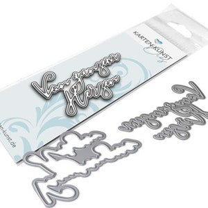 May include: Silver metal die cuts in a cursive font spelling "Vom ganzen Herzen" are displayed on a white background. The die cuts are in a package with the words "Karten Kunst" printed on it.