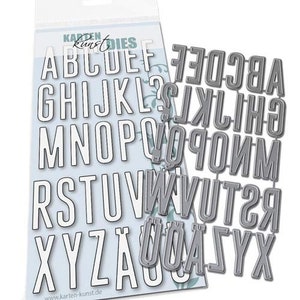 May include: A set of alphabet letter stencils for crafting. The stencils are made of metal and are in a silver color. The letters are in uppercase and are arranged in alphabetical order. The stencils are on a white background with a blue floral pattern.