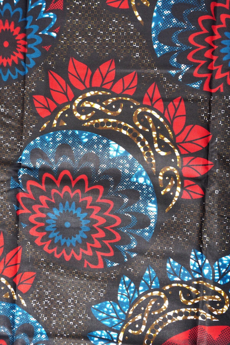 Afrikanischer Stoff mit roten-blauen Blumen auf braunem Grund.