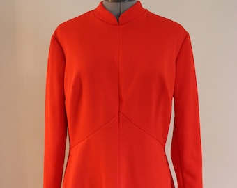 May include: A bright red dress with a mandarin collar and long sleeves. The dress has a fitted bodice and a slightly flared skirt.
