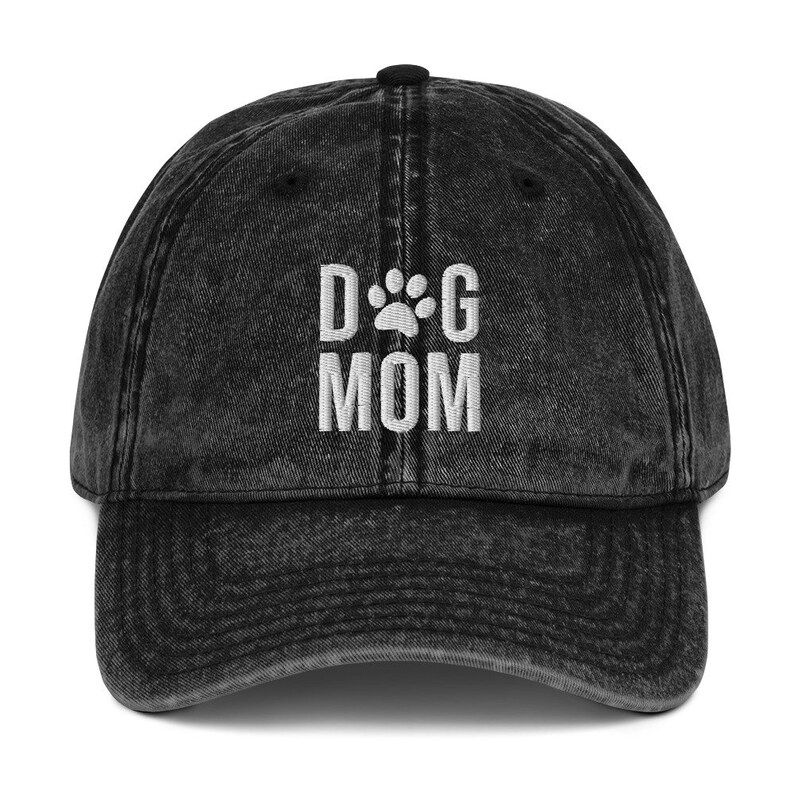 May include: Black vintage washed denim baseball cap with white embroidered text "DOG MOM" and a paw print.