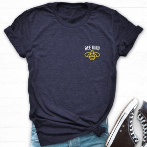 May include: A navy blue t-shirt with a yellow bee graphic and the text "Bee Kind" on the front.