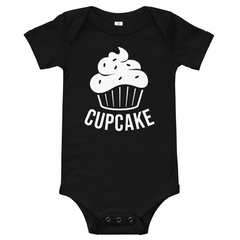 May include: Black baby onesie with a white cupcake graphic and the word "CUPCAKE" printed below it.