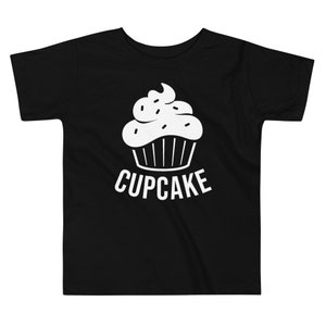 May include: Black toddler t-shirt with a white cupcake graphic and the word "CUPCAKE" printed below it.