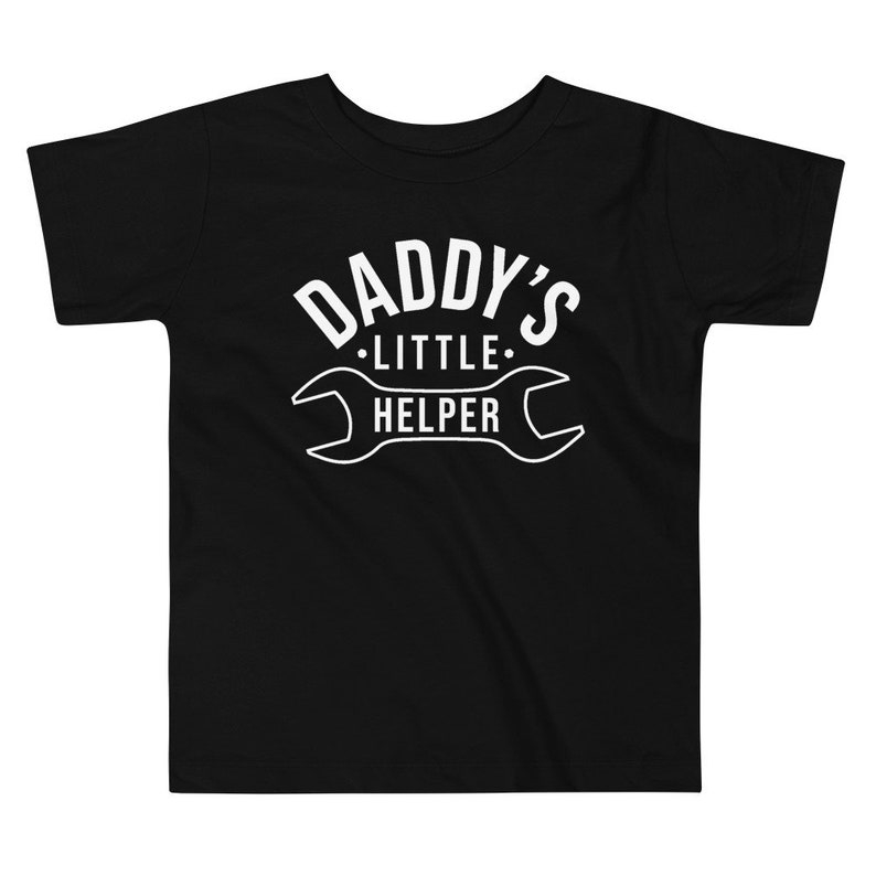 K&ouml;nnte beinhalten: Schwarzes T-Shirt mit kurzen &Auml;rmeln mit wei&szlig;em Text "Daddy's Little Helper" und einer Schraubenschl&uuml;sselgrafik.