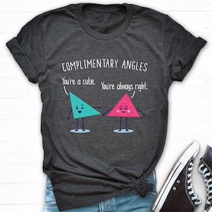 Pode incluir: Uma camiseta cinza escura com o texto "COMPLIMENTARY ANGLES You're a cutie. You're always right." e dois tri&acirc;ngulos de desenho animado com rostos.
