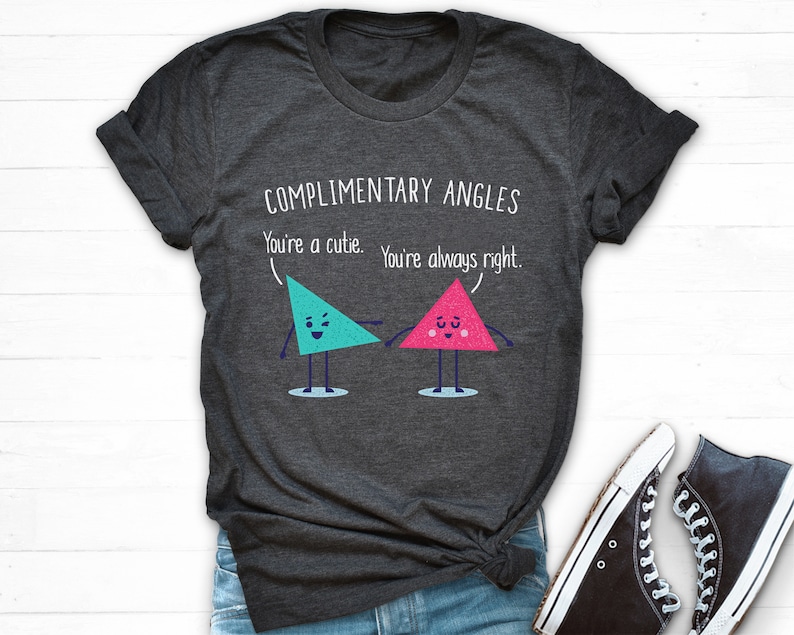 Pode incluir: Uma camiseta cinza escura com o texto "COMPLIMENTARY ANGLES You're a cutie. You're always right." e dois tri&acirc;ngulos de desenho animado com rostos.