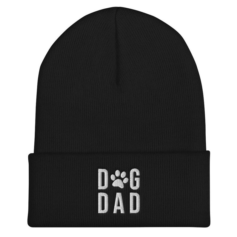 May include: Black knit beanie with a white embroidered paw print and the text "DOG DAD".