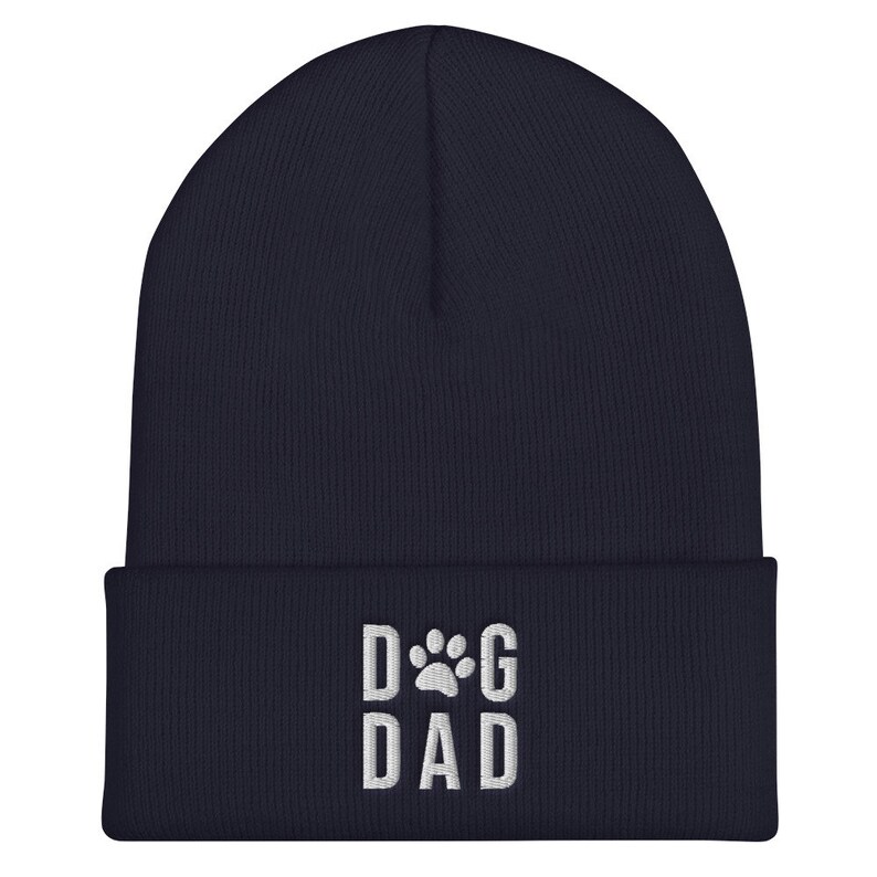 May include: Navy blue beanie with a white embroidered paw print and the text "DOG DAD".