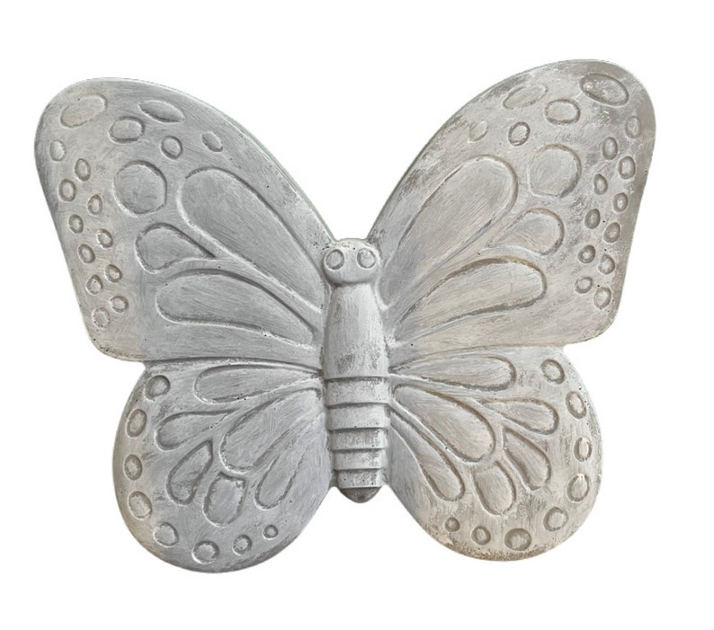 May include: A decorative, gray butterfly sculpture with detailed wing patterns and a textured finish. The butterfly has a symmetrical design with rounded wing tips and a segmented body, perfect for garden decor.