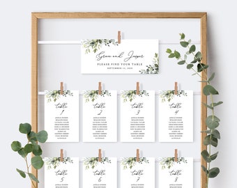 May include: A set of eight white table cards with green foliage and calligraphy. The top card reads "Grace and Jasper, Please Find Your Table, September 11, 2010". The remaining cards are numbered 1 through 8 and list guest names.