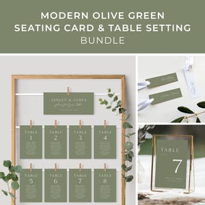 Puede incluir: Tarjetas de número de mesa de boda verde oliva con texto blanco. Las tarjetas se muestran en un marco de madera con clips. Las tarjetas están numeradas del 1 al 8. También hay una tarjeta de número de mesa más grande con el número 7 en un marco dorado.