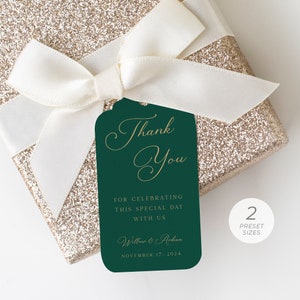 Puede incluir: Una etiqueta de regalo verde con letras doradas que dice "Gracias" y "POR CELEBRAR ESTE DÍA ESPECIAL CON NOSOTROS". La etiqueta también incluye los nombres "Willow & Ardian" y la fecha "NOVIEMBRE 17, 2024".