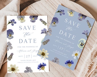 Puede incluir: Dos tarjetas de guardar la fecha con un diseño floral. Las tarjetas son blancas y azul claro con flores prensadas. El texto en las tarjetas dice "Save the Date" para la boda de Allison y Joseph el 27 de septiembre de 2025 en Noosa Heads, QLD.