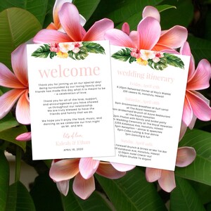 May include: A pink and green tropical floral wedding invitation with a welcome message and a wedding itinerary. The welcome message says "Thank you for joining us on our special day! Being surrounded by our loving family and friends has made this day what it is meant to be - a celebration of love." The wedding itinerary includes the date and time of the rehearsal dinner, groomsmen breakfast, bridesmaid brunch, wedding ceremony, reception, and farewell brunch. The invitation is decorated with pink and white flowers and green leaves.