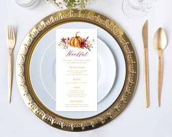 May include: A Thanksgiving dinner menu featuring a watercolour illustration of a pumpkin and autumn foliage. The menu is titled "Thankful" and lists the starters, main course, side dishes, and dessert.