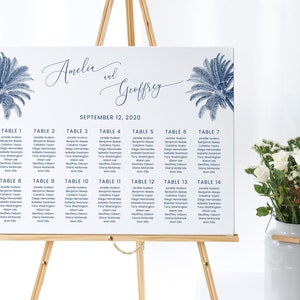 May include: A wedding seating chart with a blue and white colour scheme. The chart is on an easel and features the names "Amelia and Geoffrey" and the date "September 12, 2020". The chart lists tables 1 through 14 with guest names.