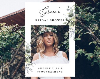 May include: A white photo booth frame with a floral design and the text "Grace's Bridal Shower" at the top. The frame has a space for a photo in the middle and the text "August 3, 2019 #YOURHASHTAG" at the bottom.