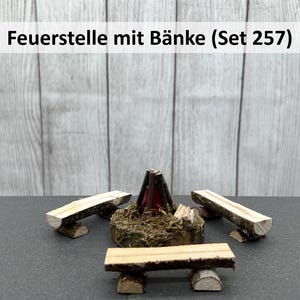 Könnte beinhalten: Ein Miniatur-Holzkamin mit drei Holzbänken. Der Kamin ist aus braunem Holz und hat einen roten und schwarzen Schornstein. Die Bänke sind aus hellem braunem Holz. Das Set ist mit "Feuerstelle mit Bänke (Set 257)" beschriftet.