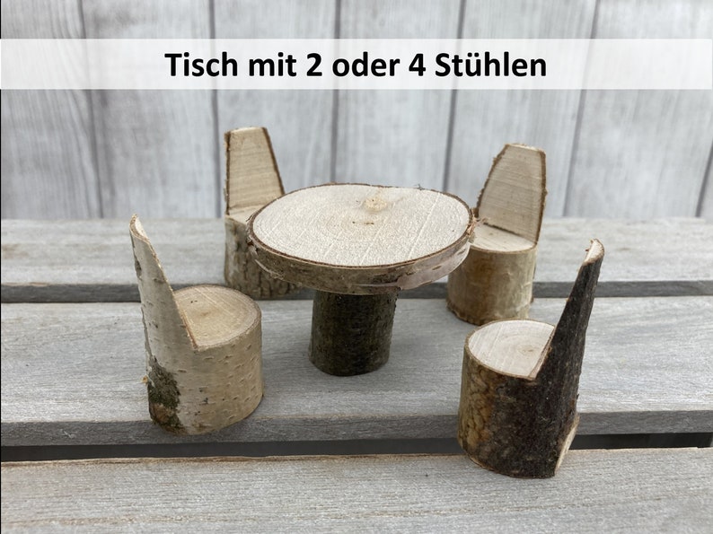 May include: A miniature wooden table and chairs set. The table is made from a round piece of wood with a smaller piece of wood for a base. The chairs are made from individual pieces of wood with a back and seat. The set is made of natural wood with a light brown colour.