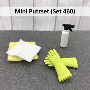Könnte beinhalten: Ein Mini-Reinigungsset mit einer weißen Sprühflasche, gelben Handschuhen, einem gelben Schwamm und einem weißen Tuch. Das Set ist mit "Mini Putzset (Set 460)" beschriftet.