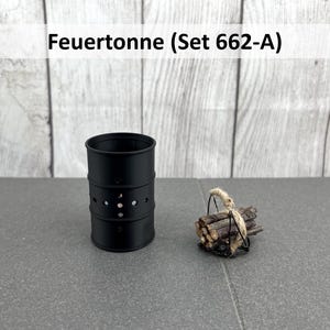 Könnte beinhalten: Schwarze Metall-Feuerstelle mit kreisförmigen Lüftungslöchern und einem Bündel kleiner Holzscheite, die mit Bindfaden zusammengebunden sind. Der Text "Feuertonne (Set 662-A)" befindet sich oben im Bild.