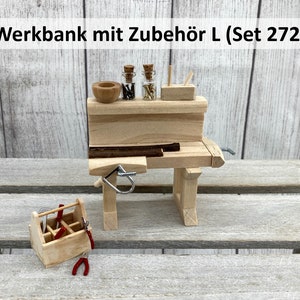 Könnte beinhalten: Eine Holzwerkbank mit einer kleinen Holzkiste, zwei Glasbehältern mit Metallschrauben, einer Holzschale und einem Holzblock mit einem kleinen Holzstift. Die Werkbank ist mit "Werkbank mit Zubehör L (Set 272)" beschriftet.