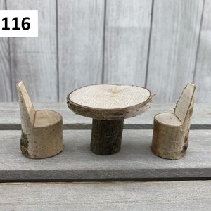 May include: Set of three miniature wooden furniture pieces, including a round table and two chairs, all made from natural birch wood. The set is labelled "Set 116".