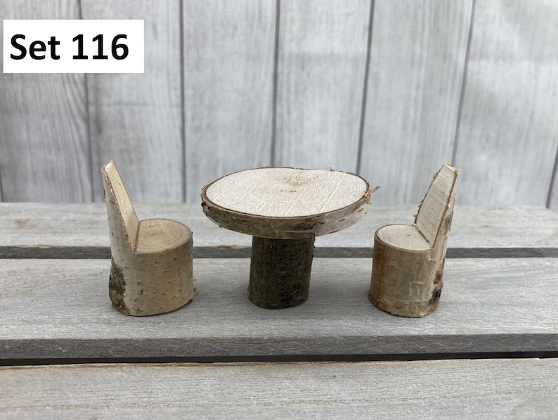 May include: Set of three miniature wooden furniture pieces, including a round table and two chairs, all made from natural birch wood. The set is labelled "Set 116".