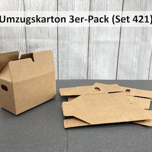 Könnte beinhalten: Ein Satz aus drei braunen Umzugskartons mit einem Griff an jeder Seite. Die Kartons sind flach zusammengefaltet und übereinander gestapelt. Der Text "Umzugskarton 3er-Pack (Set 421)" ist auf einem weißen Hintergrund über den Kartons gedruckt.