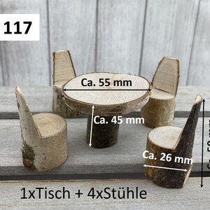 May include: A set of miniature wooden furniture, including a table and four chairs, made from birch wood. The table is 14 cm in diameter and 11.4 cm tall. The chairs are 12.7 cm tall and 6.6 cm wide. The set is labelled "Set 117" and "1xTisch + 4xSt&uuml;hle".
