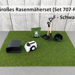 Könnte beinhalten: Ein Miniatur-Rasenpflegeset bestehend aus einer schwarzen Mähroboter-Garage, einem weißen Mähroboter, einem grünen Samentütchen mit der Aufschrift 'SAMEN 20 KG', einer schwarzen Schaufel, einem schwarzen Rechen mit Holzstielen und einem schwarzen Topf.