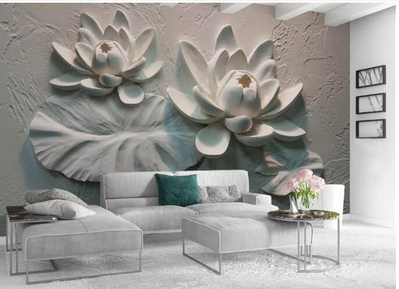 K&ouml;nnte beinhalten: Eine wei&szlig;e 3D-Wandmalerei mit zwei gro&szlig;en wei&szlig;en Lotusblumen mit Bl&auml;ttern. Die Wandmalerei ist in einem Wohnzimmer mit einem wei&szlig;en Sofa und einem Couchtisch dargestellt.